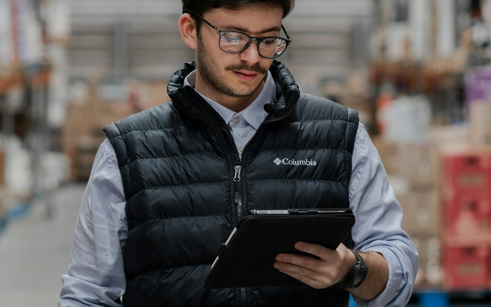 A business operations worker using a tablet in a modern warehouse