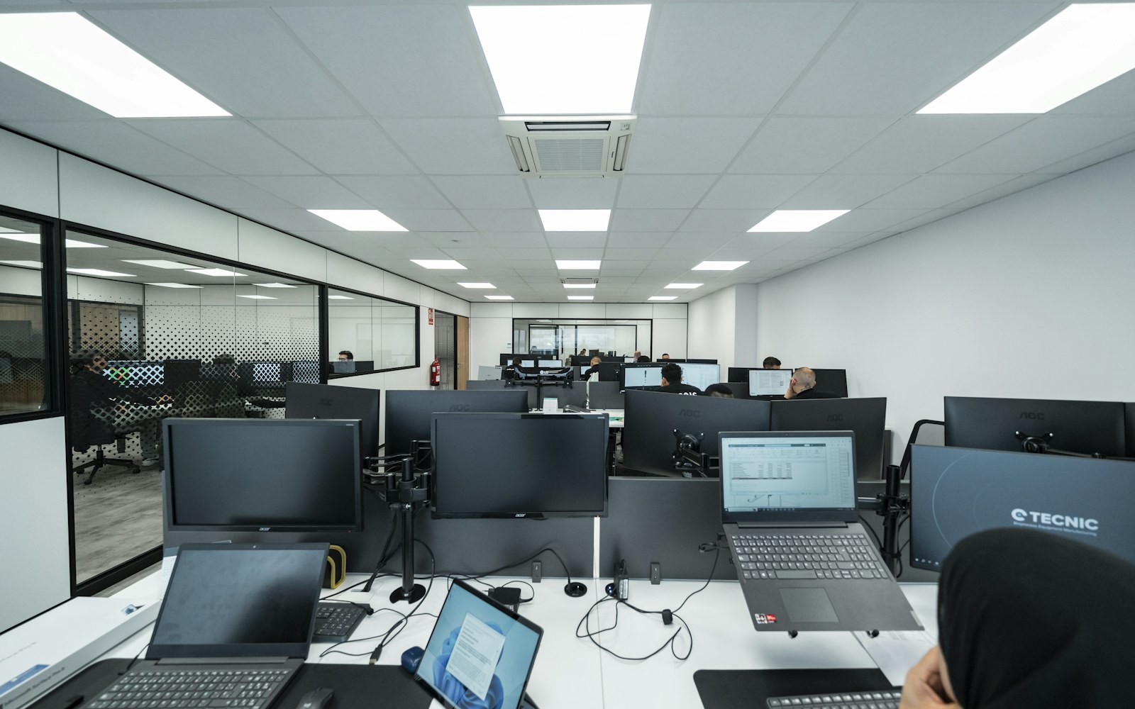 A technical team working at computers in a modern business office